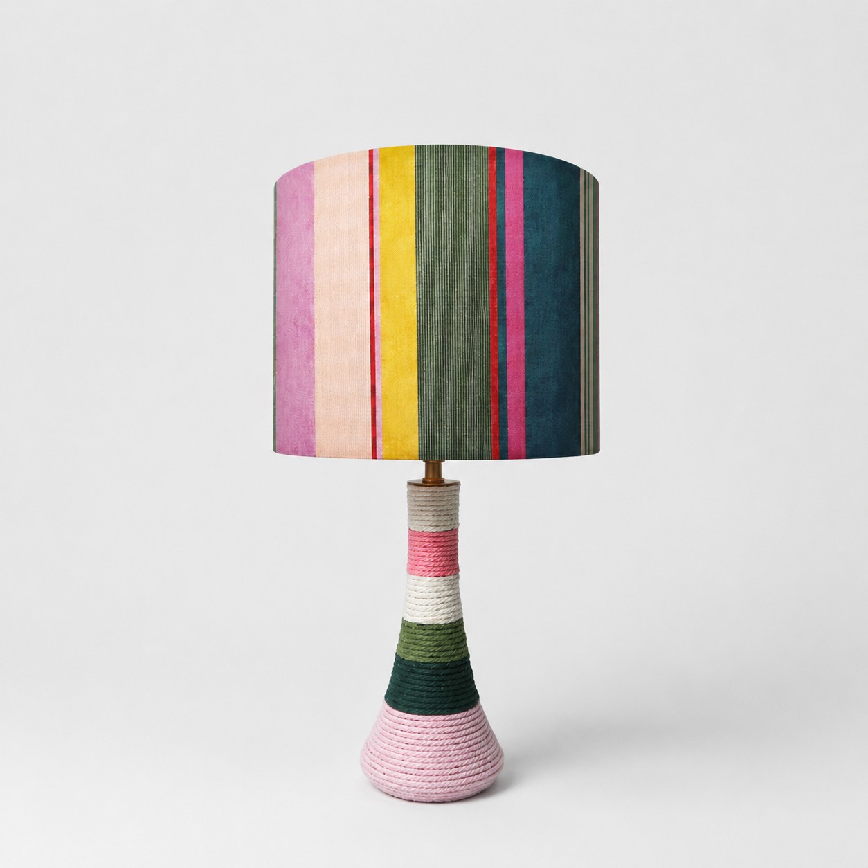Colorful striped fabric table lamp with cotton thread wrapped ceramic base on white background