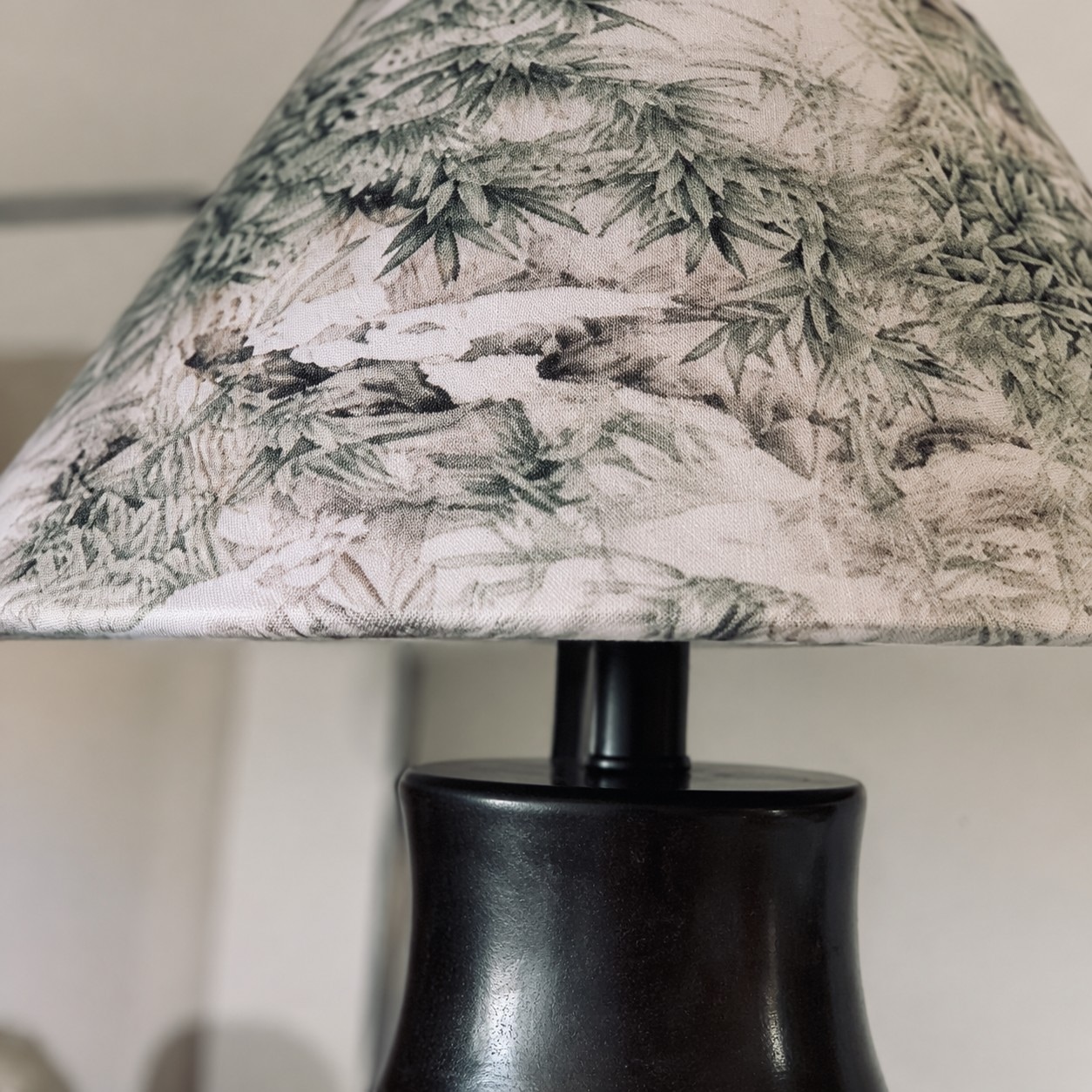 Close view of botanical shade print and dark ceramic body